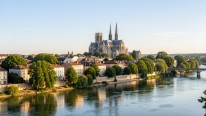 Vue lumineuse de Tours depuis les quais de Loire, avec la cathédrale Saint-Gatien et les toits du centre historique au loin.